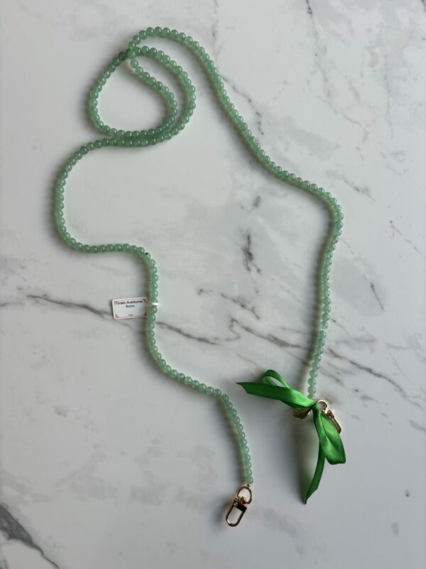 Chaine de téléphone en aventurine. L'aventurine verte, une pierre précieuse d'une beauté éclatante, est réputée pour ses vertus apaisantes et revitalisantes. Sa teinte naturelle évoque la luxuriance des forêts verdoyantes, tandis que ses propriétés ésotériques invitent à l'équilibre et à la croissance personnelle. Que ce soit pour trouver la chance, favoriser la prospérité ou renforcer l'harmonie intérieure, l'aventurine verte offre un compagnonnage fidèle dans la quête de bien-être et d'accomplissement.